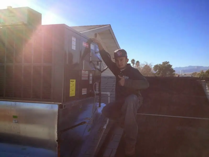 HVAC technician performing AC Tune-Up on a rooftop unit in Floris